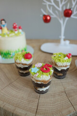 Baking cakes and cupcakes decorated in forest style, grass, mushrooms and a little princess