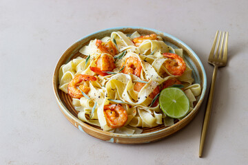 Pasta fettuccine in a creamy sauce with shrimp, lime and sage. Italian food.