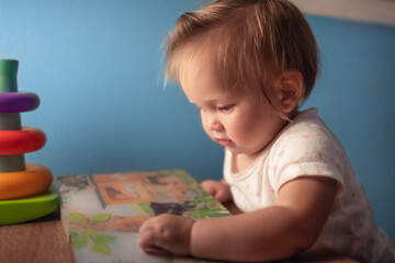 Fototapeta na wymiar Little toddler girl reading book 