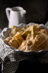 Dumplings on plates, on a dark background, food photography.