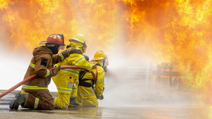 Fireman,Firefighter training Firefighters using water and fire extinguishers to fight the flames in...