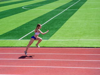 Fototapeta premium Young caucasian woman is engaged in jogging at the stadium outdoors.