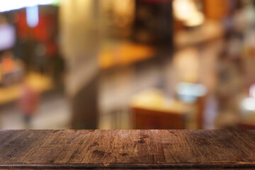 Empty dark wooden table in front of abstract blurred bokeh background of restaurant . can be used for display or montage your products.Mock up for space.