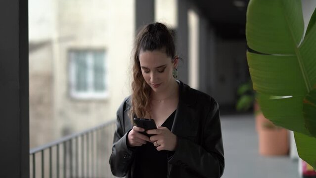 Caucasian young female in a black causal outfit with suitcase chatting on phone