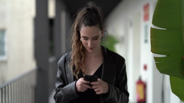 Caucasian young female in a black causal outfit with suitcase chatting on phone