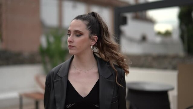 Caucasian young female in a black causal outfit with suitcase  walking