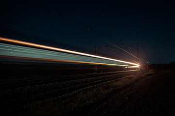 Fototapeta na wymiar Luminous paths created at night by a passenger train.