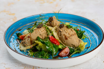 pate with microgreens, spinach cones and bruschetta in a blue plate
