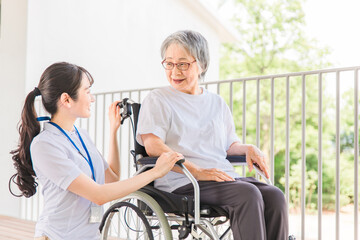 散歩する介護士・理学療法士と高齢者女性（日本人）

