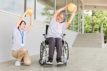 Fototapeta na wymiar ボール体操する高齢者女性と理学療法士 