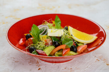 Greek salad in a red plate on a white background
