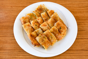 Turkish style meat stuffed filo dough borek served kol boregi. Cheese and minced pie are sliced on a marble background. Turkish name: Kol Boregi.