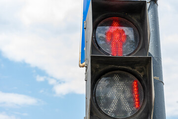 Red traffic light for pedestrians on the background of the blue sky. Red number 1 at the traffic...