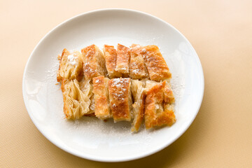 Turkish style meat stuffed filo dough borek served kol boregi. Cheese and minced pie are sliced on a marble background. Turkish name: Kol Boregi.