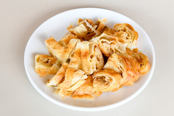 Turkish style meat stuffed filo dough borek served kol boregi. Cheese and minced pie are sliced on a marble background. Turkish name: Kol Boregi.