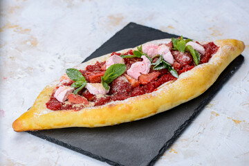 oriental flatbread with cheese and strawberries and mint leaves
