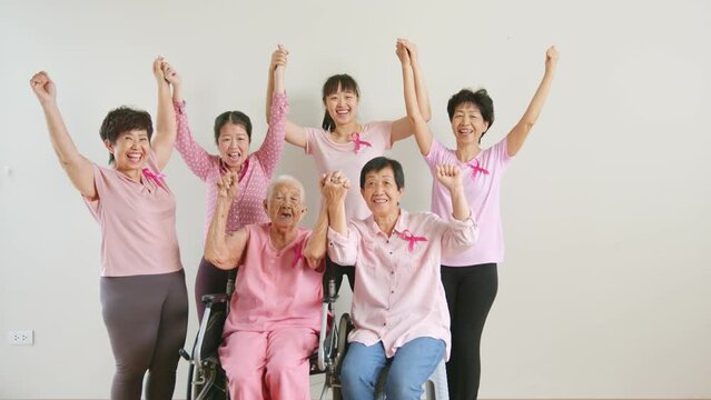Group of Asian multi-age women power in pink shirt and pink ribbon for October Breast Cancer Awareness month