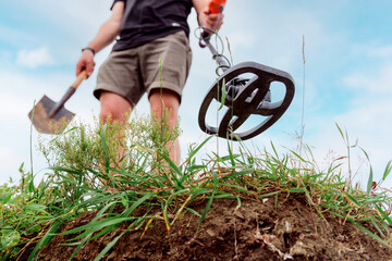 metal detector at work in the forest or field. Search for treasure and ancient values. Archeology....