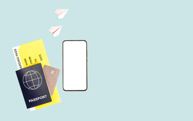 Banner with phone mockup for travel app, passport, boarding pass, credit card on blue background. Paper origami planes. Going on trip by air. Place for text. High quality photo