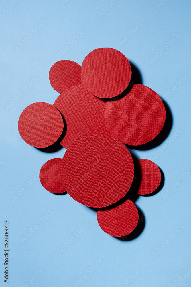 Poster different red textured circles soar as swarm shape on blue background, decorative space for text, co