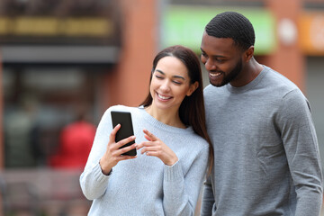 Happy interracial couple checking cell phone