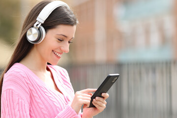 Happy teen listening to music using phone