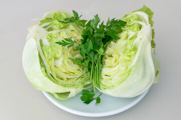 Fresh green iceberg ( Marul ) lettuce salad leaves cut on light background on the table in the kitchen.