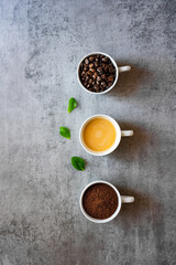 Obraz na płótnie Canvas Kaffee Variationen in drei weißen Tassen auf einem Beton Hintergrund. Draufsicht, Frühstück.