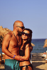Fototapeta premium Beautiful Happy Couple hugging and kissing enjoying Vacation holidays at luxurious Beachfront villa near the beach