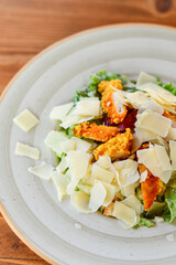 Caesar salad with lettuce,chicken ,parmesan cheese and croutons on wooden table in  a beach restaurant