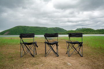 Three empty camping chairs at the Huai Phak Reservoir, Tha Yang District, Phetchaburi, Thailand.