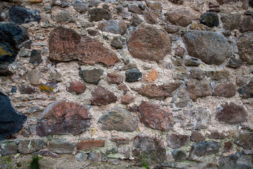 Ancient stone wall. Weathered rough masonry surface. The wall of the old castle. Vintage texture great for background and design.