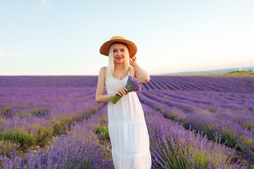 Young woman in long white dress standing in lavender field