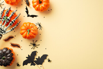 Halloween concept. Top view photo of skeleton hand holding pumpkin spiders cockroach centipedes bat...