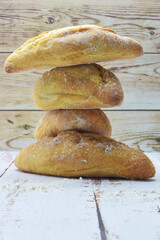Stacked rustic loaves, on wooden background.