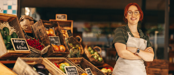 Happy supermarket owner smiling at the camera in her shop