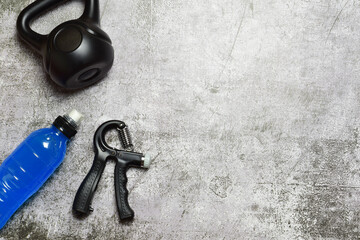 Hand grip fitness training and various accessories, on a stone background. Copy space.