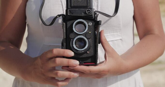 A woman presses the button on the camera and takes a picture