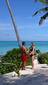 Beautiful shot of a couple at the beach with palm trees