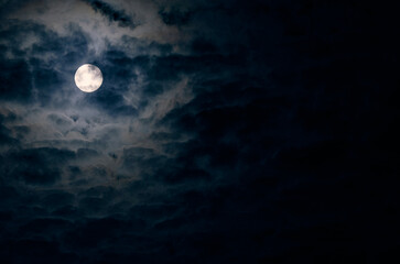 midnight sky view. moon covered by clouds.