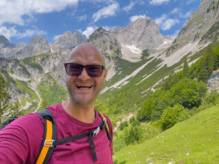 Happy Man hiking the hill and sweat with a smile after achievement  - obrazy, fototapety, plakaty