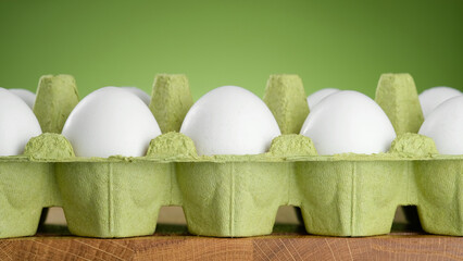 White eggs in green egg packing. Chicken Eggs In green Eggshell Cardboard Box