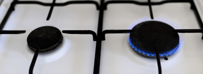 Old gas stove with blue flame. Saving energy, crisis, price increase.