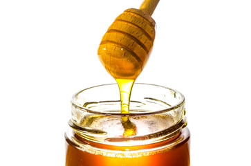 Honey on dipper from a jar