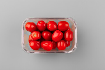 Naklejka na ściany i meble Glass box with fresh cherry tomatoes. Vegetables in a glass containers. Food storage concept