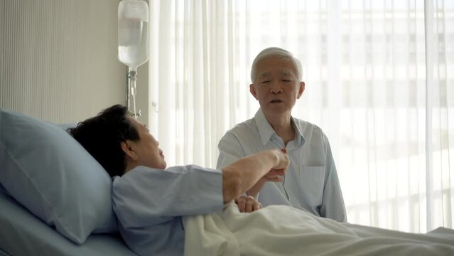 worry free relax Asian senior couple in hospital talking smile laugh happy while recovery