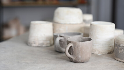  Set of handmade ceramic tableware and pottery on table in creative studio