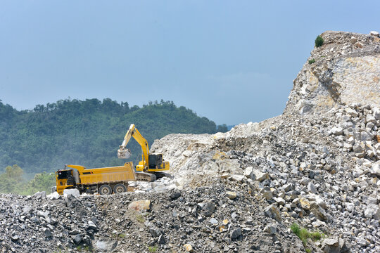 Excavator dig ground at construction site. Earthmover on road construction. Heavy equipment and machinery. Backhoe on earthwork. Open pit development and sand extraction. Mining industry Reserves.