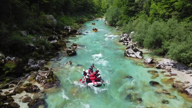 Soca Valley, Slovenia - 4K Aerial shot of white water rafting on River Soca. Whitewater rafting teams going down the emerald alpine river Soca on a bright summer day