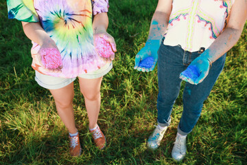 Women with colorful powder dyes outdoors, closeup. Holi festival celebration